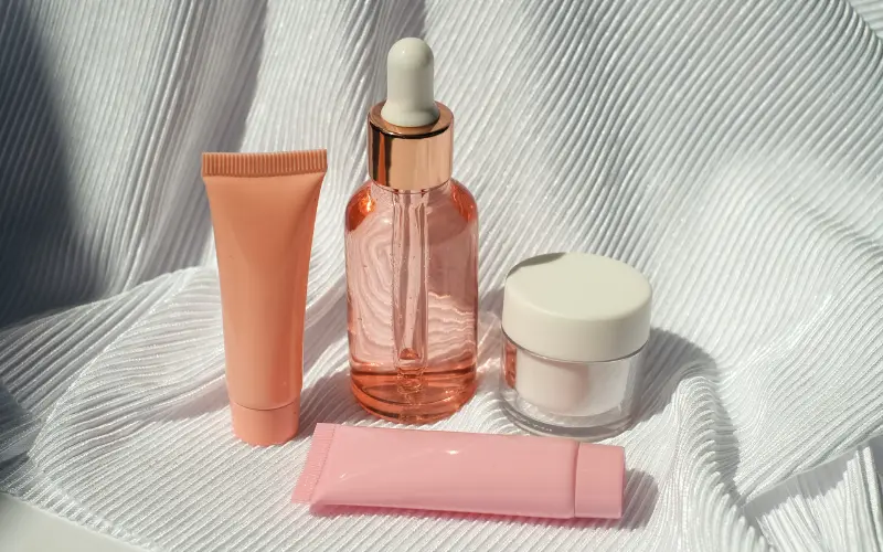 pink skincare products in morning light representing morning skincare routine steps including cleanser serum SPF and moisturiser