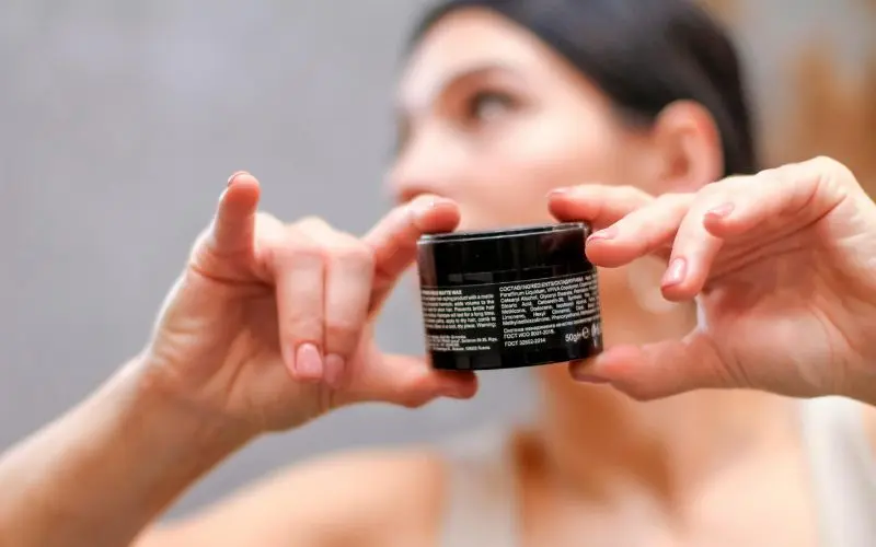 reading skincare product label to check for pore-clogging comedogenic ingredients