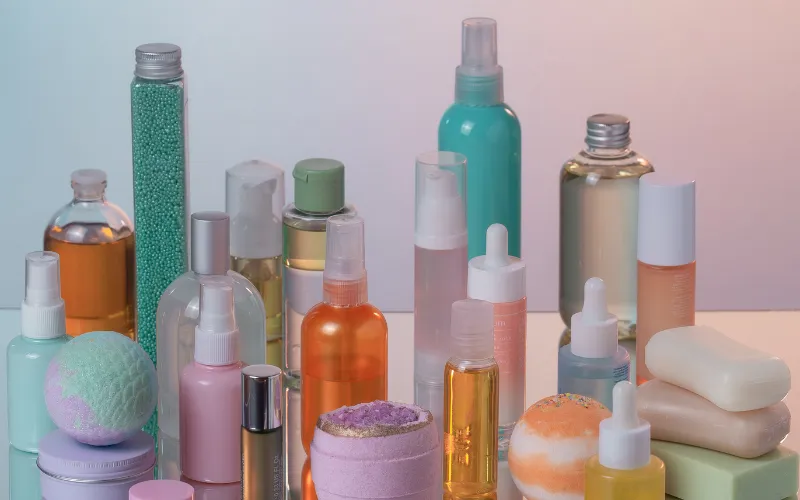 Multiple skincare products crowded together on a surface showing over-layering before makeup application