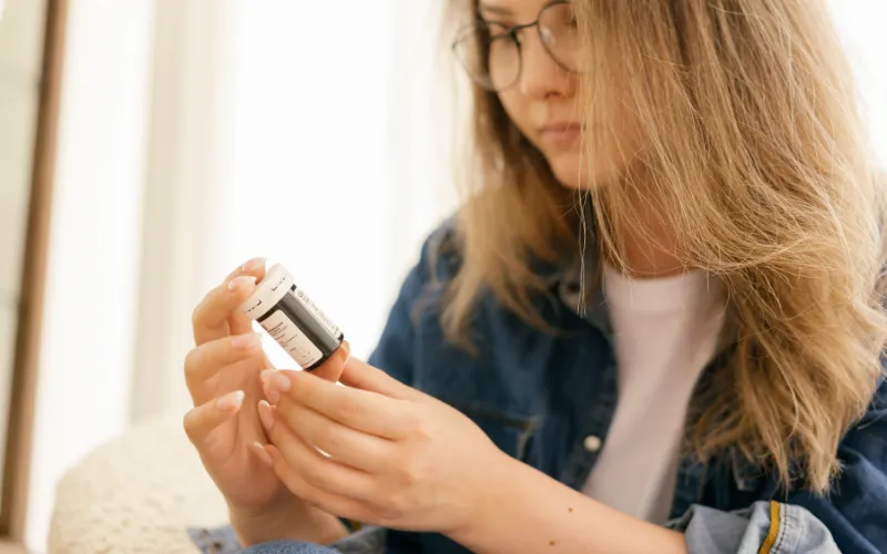 Woman closely reading a skincare product label to check where an ingredient sits on the list